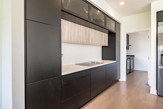 54598 Deadwood Ln, Utica, MI 48316 - kitchen featuring modern cabinets, light countertops, light wood finished floors, glass insert cabinets, and stainless steel refrigerator with ice dispenser