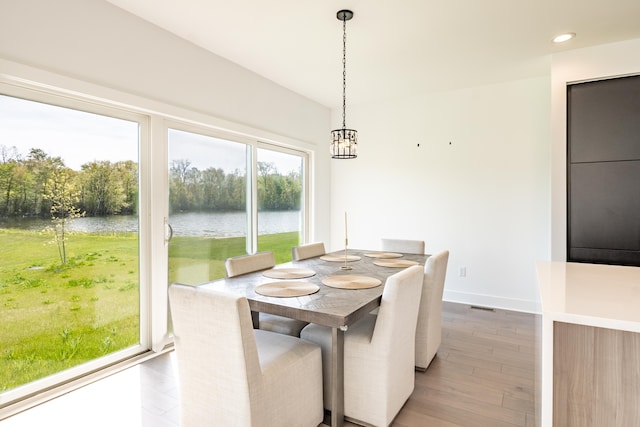 54598 Deadwood Ln, Utica, MI 48316 - dining space featuring a water view, light wood-style flooring, a chandelier, baseboards, and recessed lighting