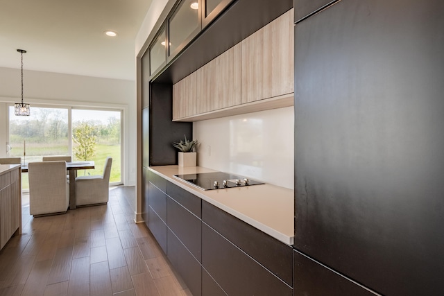 54598 Deadwood Ln, Utica, MI 48316 - kitchen featuring modern cabinets, black electric stovetop, light countertops, a chandelier, and refrigerator