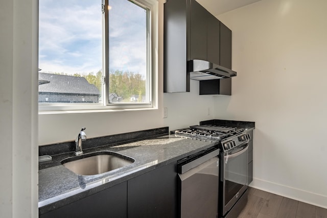 54598 Deadwood Ln, Utica, MI 48316 - kitchen with range with gas stovetop, a sink, under cabinet range hood, stainless steel dishwasher, and dark cabinetry