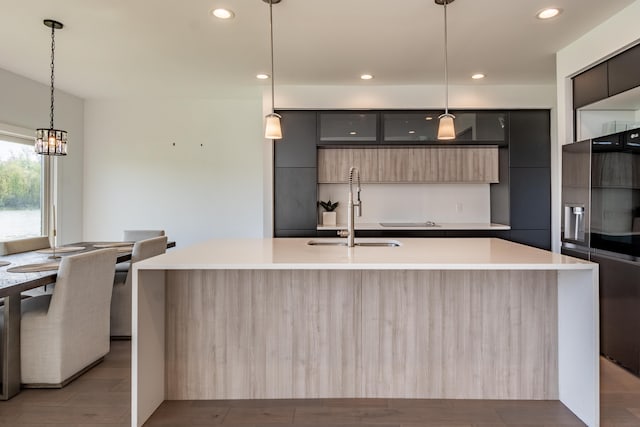 54598 Deadwood Ln, Utica, MI 48316 - kitchen with modern cabinets, a sink, a center island with sink, light countertops, and recessed lighting