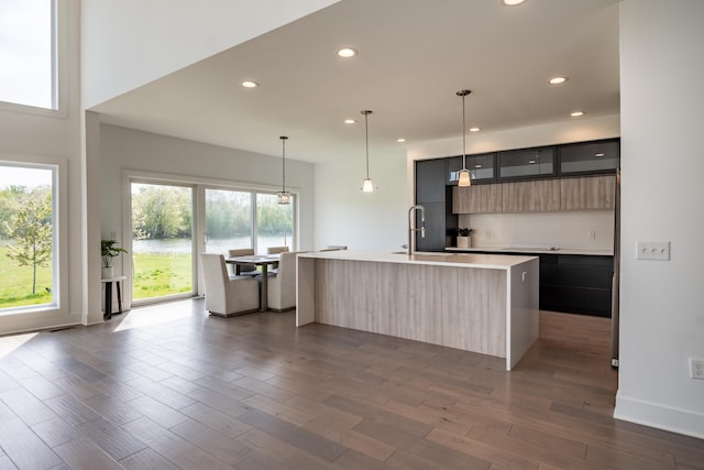 54598 Deadwood Ln, Utica, MI 48316 - kitchen with modern cabinets, a sink, light countertops, a center island with sink, and dark wood finished floors