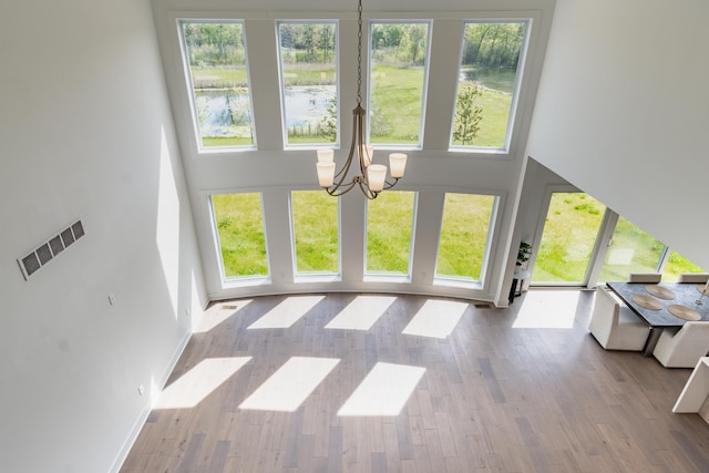 54598 Deadwood Ln, Utica, MI 48316 - living area featuring a chandelier, a towering ceiling, healthy amount of natural light, wood finished floors, and baseboards