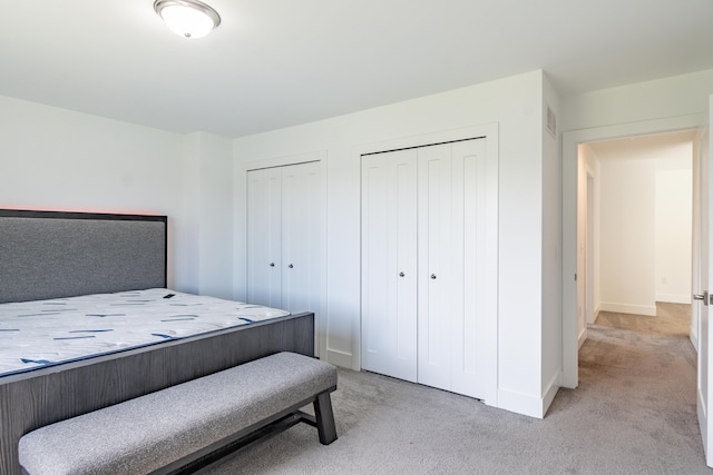 54598 Deadwood Ln, Utica, MI 48316 - bedroom featuring light colored carpet, two closets, and baseboards