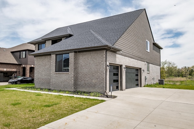54598 Deadwood Ln, Utica, MI 48316 - view of side of property with concrete driveway, a garage, a shingled roof, and brick siding