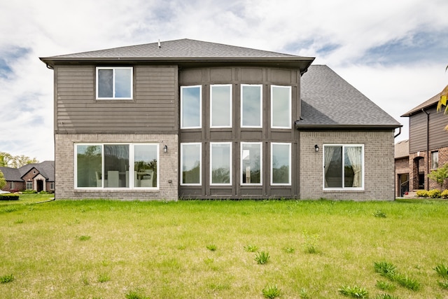 54598 Deadwood Ln, Utica, MI 48316 - rear view of house featuring brick siding, a lawn, and roof with shingles