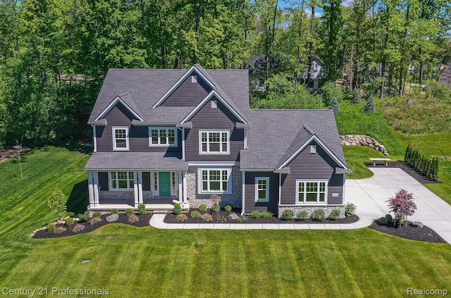 9058 Fielding Dr, Brighton, MI 48116 - craftsman-style house featuring stone siding, a porch, a front yard, and driveway