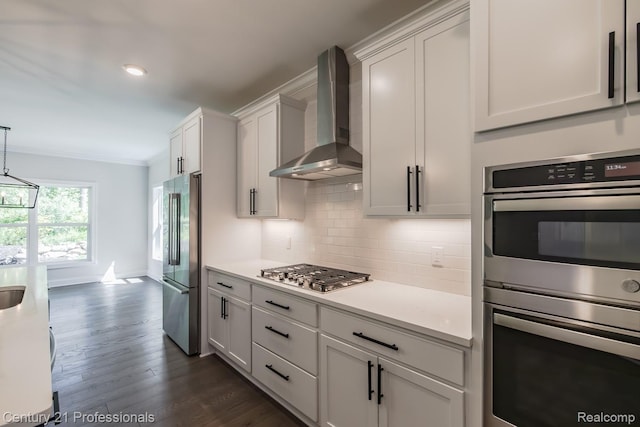 9058 Fielding Dr, Brighton, MI 48116 - kitchen with wall chimney exhaust hood, stainless steel appliances, backsplash, light countertops, and crown molding