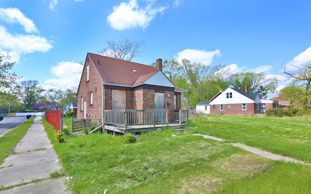 14903 Woodmont Ave, Detroit, MI 48227 - rear view of house featuring brick siding, a deck, and a chimney