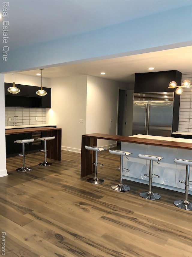 145 Westchester Way, Birmingham, MI 48009 - bar with stainless steel built in refrigerator, wood finished floors, baseboards, recessed lighting, and decorative backsplash