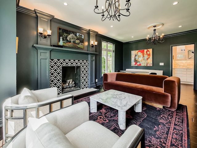 living area with a chandelier, wood finished floors, recessed lighting, crown molding, and a fireplace