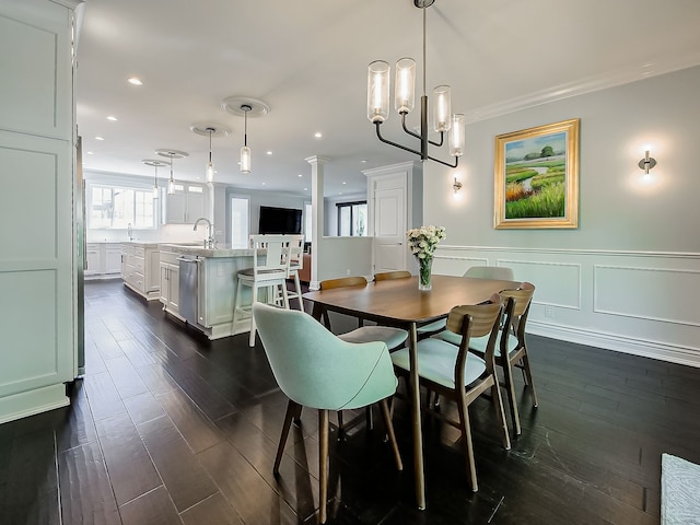 dining space with dark wood finished floors, crown molding, recessed lighting, and wainscoting