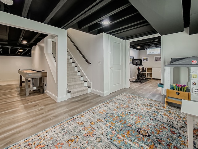 finished basement featuring wood finished floors, stairs, and baseboards