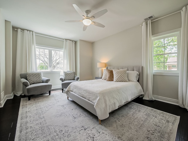 bedroom with dark wood-style floors, baseboards, and ceiling fan