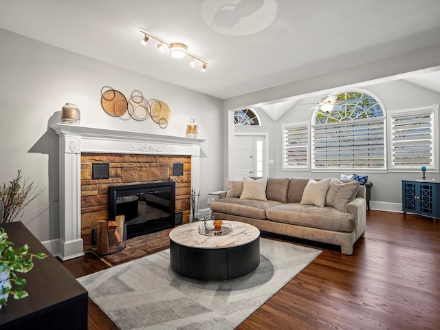 270 S Center St, Northville, MI 48167 - living area featuring a fireplace, vaulted ceiling, dark wood-style floors, ceiling fan, and baseboards