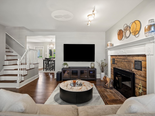 270 S Center St, Northville, MI 48167 - living room with stairway, wood finished floors, a fireplace, a chandelier, and baseboards