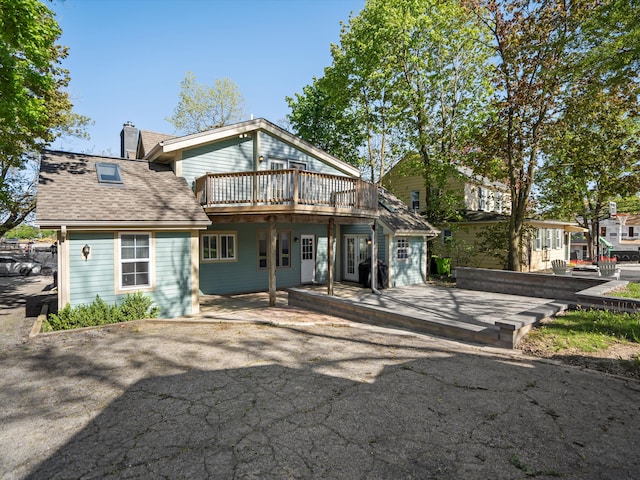 270 S Center St, Northville, MI 48167 - back of house with a wooden deck, a chimney, a shingled roof, and a patio