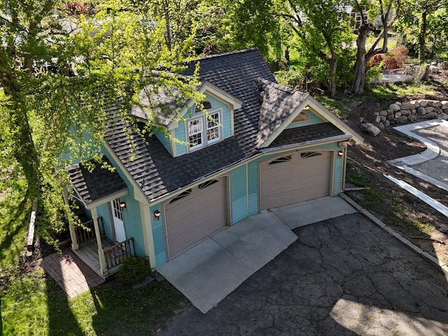 270 S Center St, Northville, MI 48167 - view of side of home featuring asphalt driveway, roof with shingles, and a porch