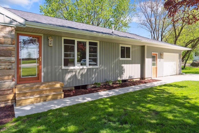 1431 E Oliver St, Owosso, MI 48867 - view of front of home with board and batten siding, roof with shingles, a front yard, concrete driveway, and an attached garage