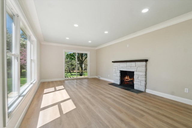 1431 E Oliver St, Owosso, MI 48867 - unfurnished living room with ornamental molding, baseboards, light wood finished floors, a stone fireplace, and recessed lighting