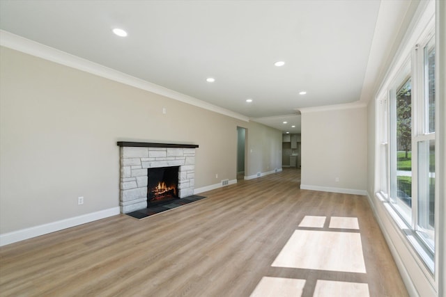 1431 E Oliver St, Owosso, MI 48867 - unfurnished living room with crown molding, baseboards, light wood finished floors, a stone fireplace, and recessed lighting
