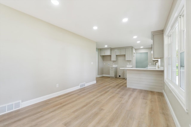 1431 E Oliver St, Owosso, MI 48867 - unfurnished living room featuring light wood-style floors, baseboards, recessed lighting, and a sink