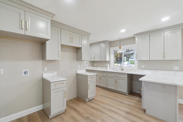 1431 E Oliver St, Owosso, MI 48867 - kitchen with baseboards, light wood-style flooring, a sink, recessed lighting, and light stone counters