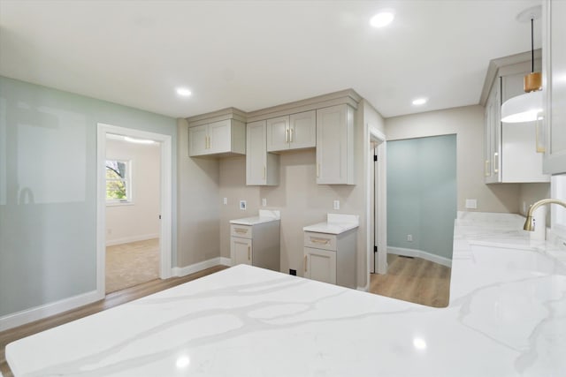 1431 E Oliver St, Owosso, MI 48867 - kitchen with a sink, light stone countertops, light wood-style flooring, baseboards, and recessed lighting