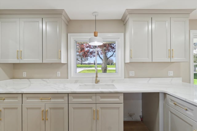 1431 E Oliver St, Owosso, MI 48867 - kitchen with a sink, hanging light fixtures, and light stone countertops