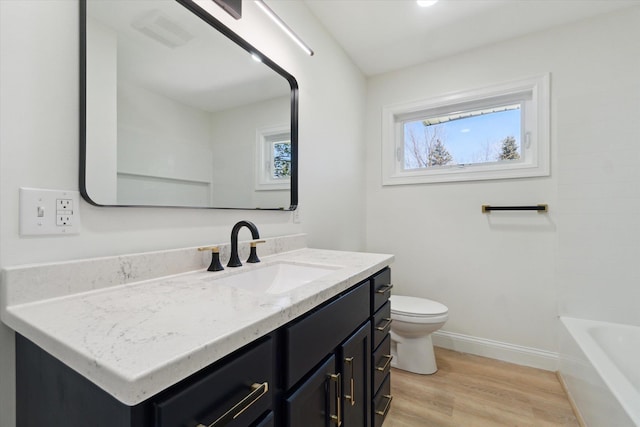 1431 E Oliver St, Owosso, MI 48867 - full bath featuring toilet, wood finished floors, vanity, and baseboards