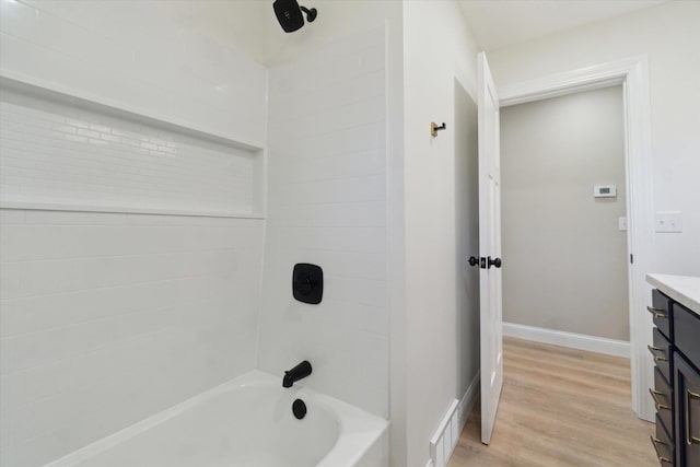 1431 E Oliver St, Owosso, MI 48867 - bathroom featuring wood finished floors, vanity, bathing tub / shower combination, and baseboards