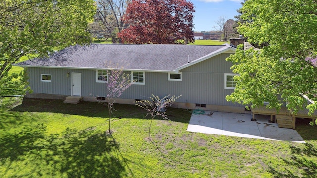 1431 E Oliver St, Owosso, MI 48867 - back of property featuring entry steps, a patio area, a shingled roof, and a lawn