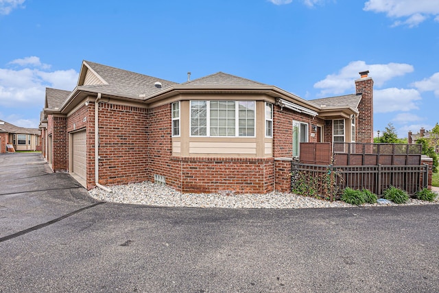 5695 Storrow Ct, Warren, MI 48092 - view of side of home featuring brick siding, an attached garage, a chimney, asphalt driveway, and a shingled roof