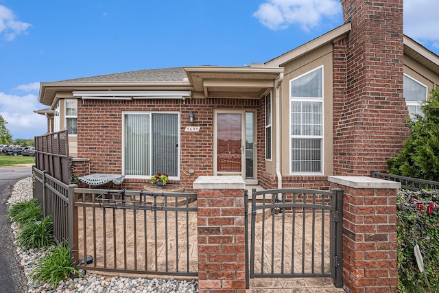 5695 Storrow Ct, Warren, MI 48092 - doorway to property featuring brick siding, a gate, and a chimney
