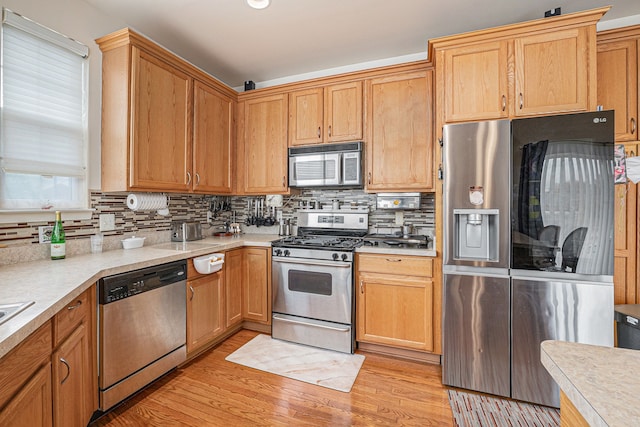 5695 Storrow Ct, Warren, MI 48092 - kitchen featuring stainless steel appliances, light countertops, tasteful backsplash, and light wood finished floors