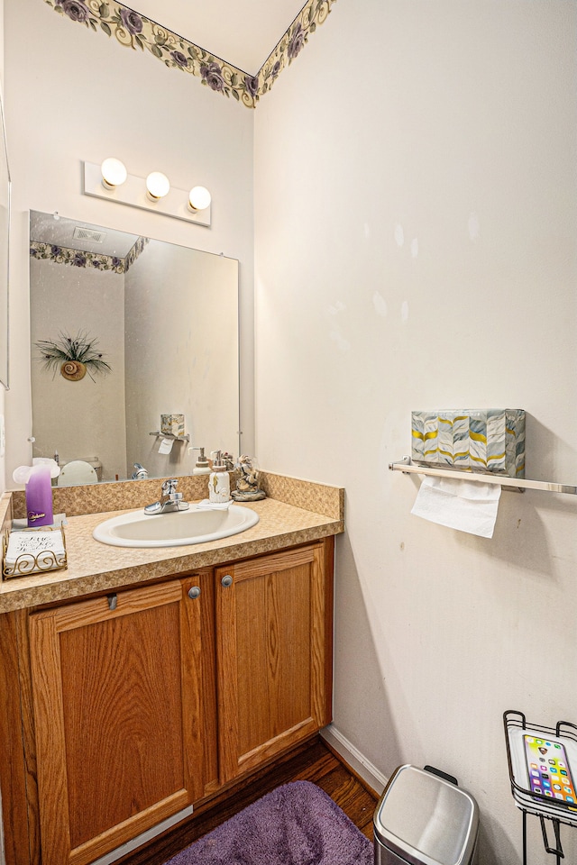 5695 Storrow Ct, Warren, MI 48092 - half bath with vanity, wood finished floors, toilet, and baseboards