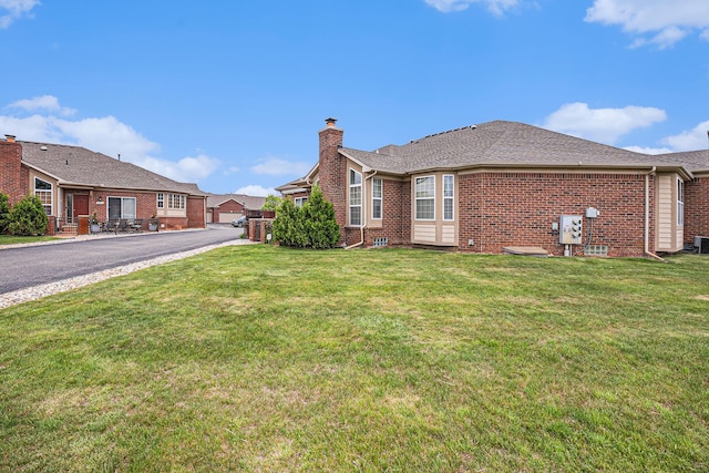 5695 Storrow Ct, Warren, MI 48092 - view of property exterior featuring a chimney, brick siding, and a yard
