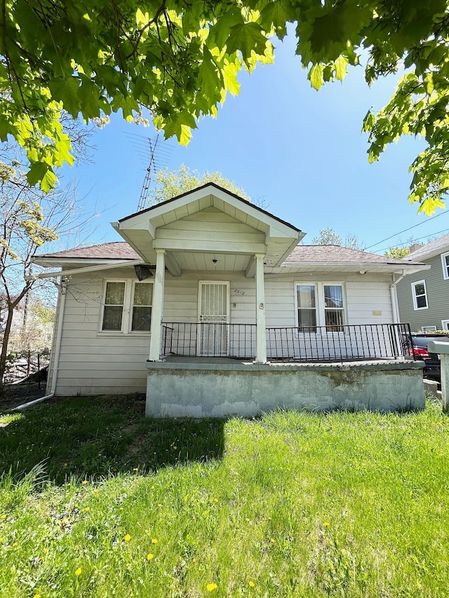 bungalow-style home with covered porch and a front lawn