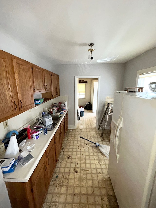 kitchen with white refrigerator with ice dispenser, light flooring, healthy amount of natural light, and light countertops