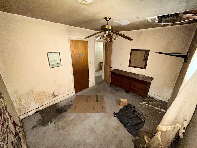 entrance foyer with ceiling fan and unfinished concrete flooring