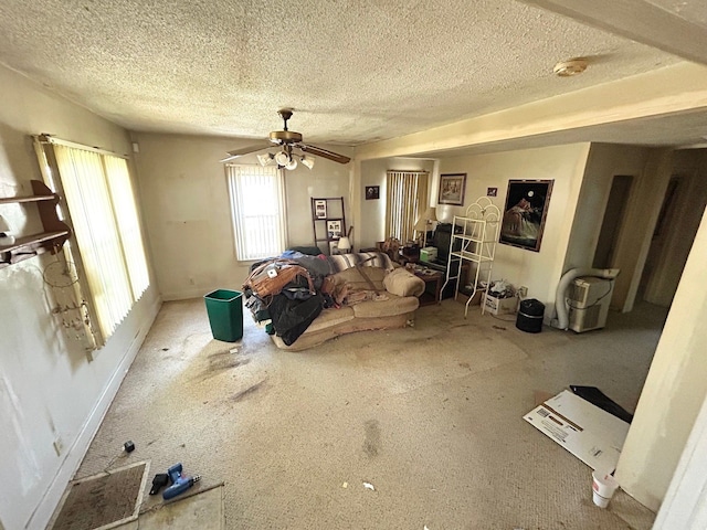 living area with a textured ceiling, ceiling fan, and baseboards