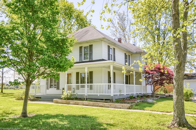 view of front facade featuring a porch, a front lawn, and a chimney