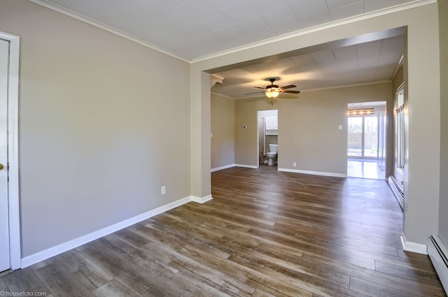 empty room with ornamental molding, baseboard heating, dark wood-style flooring, a ceiling fan, and baseboards