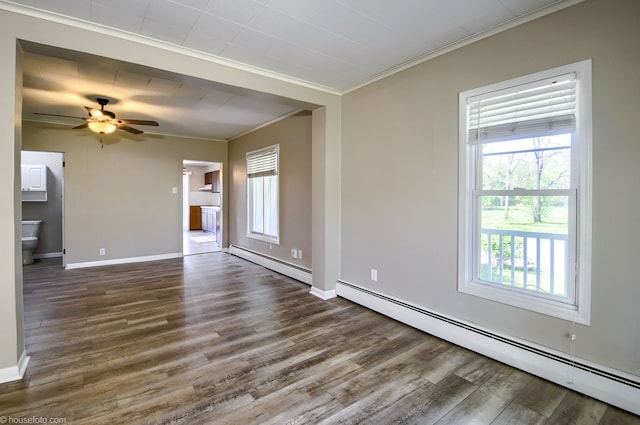 empty room with baseboard heating, crown molding, wood finished floors, baseboards, and a ceiling fan