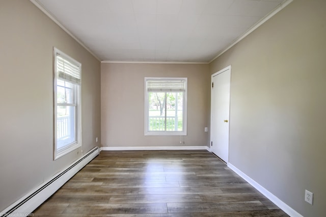 spare room featuring baseboard heating, ornamental molding, dark wood finished floors, and baseboards