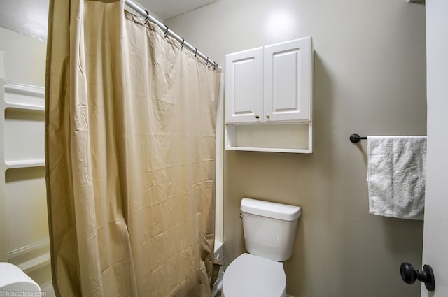 full bath with toilet and a shower with curtain