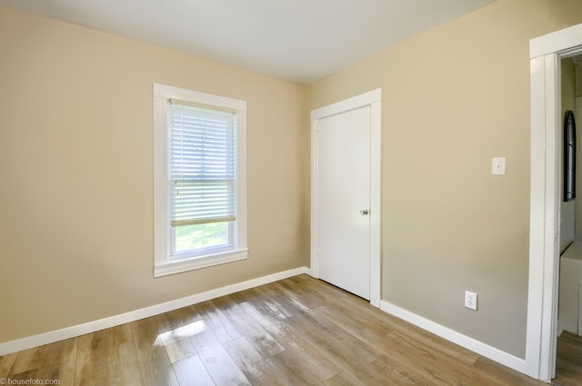 unfurnished bedroom featuring wood finished floors and baseboards