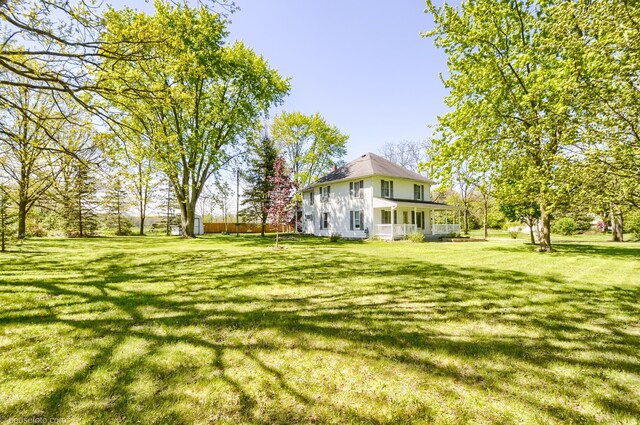 view of grassy yard featuring covered porch