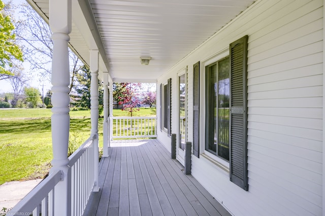 deck featuring covered porch and a yard