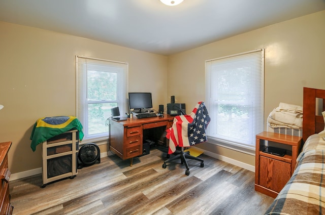 office space with healthy amount of natural light, wood finished floors, and baseboards